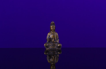 Fototapeta na wymiar Buddha of bronz on the beautiful background of blue cobalt