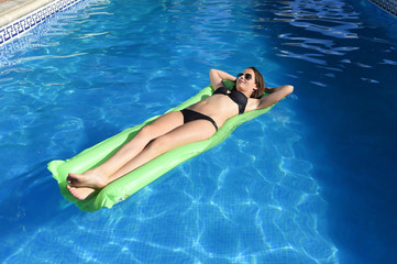 beautiful woman in bikini lying relax on float airbed at vacacti