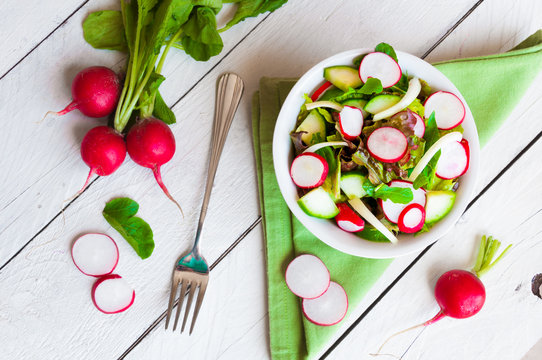 Vegetable salad with radish in a white bowl