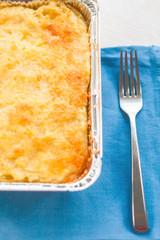 casserole in a disposable form of foil on blue napkin
