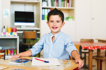 Indoor portrait of a cute little boy in a classroom