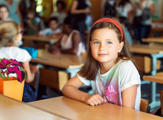 Fototapeta na wymiar Indoor portrait of a cute little girl in a classroom