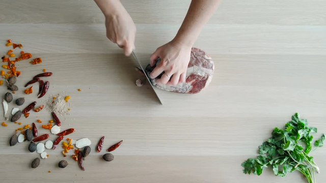 Raw Meat Slices Cutted On Wooden Board. Top View of Chefs Hands Chopping Beaf