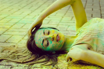 Lovely young woman with colored powder around her