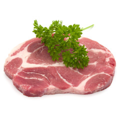 Raw pork neck chop meat with parsley herb leaves garnish isolate