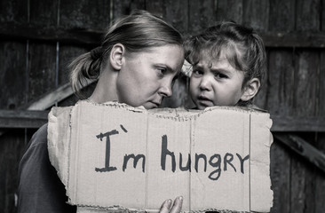 A woman with a child holding a sheet of paper. On the paper label sheet, 
