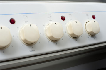 Row of control knobs on a stove
