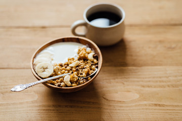 Homemade oatmeal granola with yogurt in wooden bowl