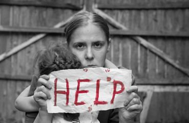 A woman with a child holding a sheet of paper. On a sheet of paper the word 