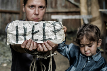 A woman with a child holding a sheet of paper. On a sheet of paper the word 
