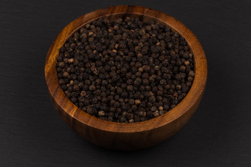Black pepper in wooden bowl
