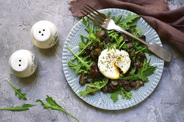 Warm mushroom salad with arugula and poached egg.Top view.