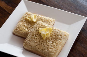 fried crumpets with butter on top