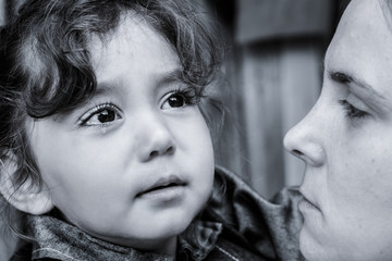 A woman holds a child, trying to calm him down. The child is three years.
