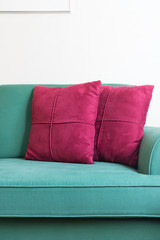 Green sofa and red backrest pillow in living room