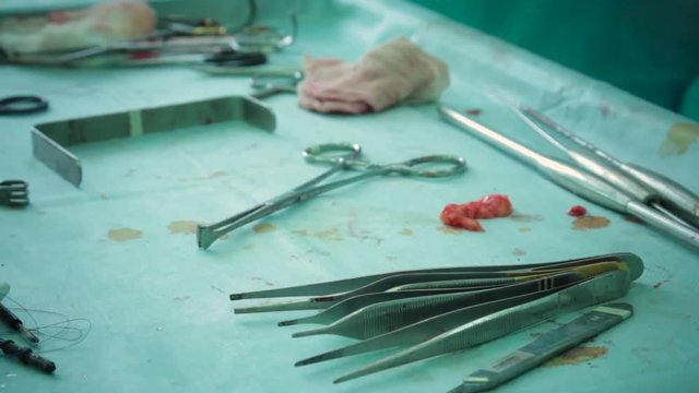 a piece of human flesh on the table with surgical instruments during surgery