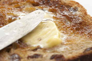 Delicious slice of bread with raisin covered with butter