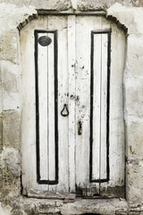 Old and worn white wooden door in Bozcaada, Canakkale, Turkey
