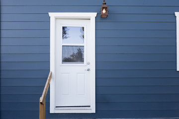 Closed white door within blue wooden background.