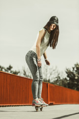 Teen girl skater riding skateboard on street. © Voyagerix