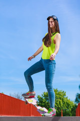 Teen girl skater riding skateboard on street.