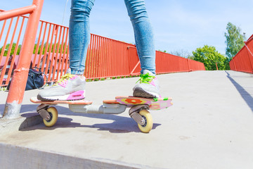 Human legs skater with skateboard on street.