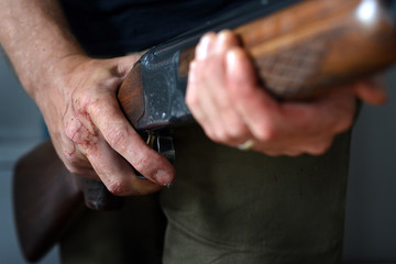 Gun held by bloody hands