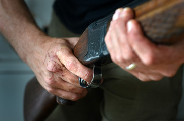 Gun held by bloody hands