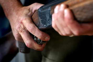Gun held by bloody hands