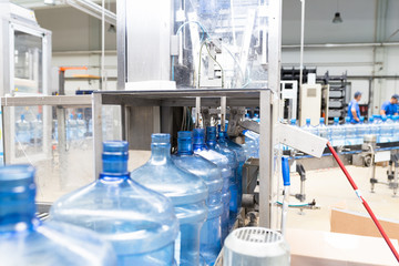 Water factory - Water bottling line for processing and bottling pure spring water into gallons. Selective focus.