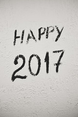 Black and white sigh of Happy 2017 year written on light wall background, closeup