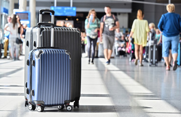 Two plastic travel suitcases in the airport hall