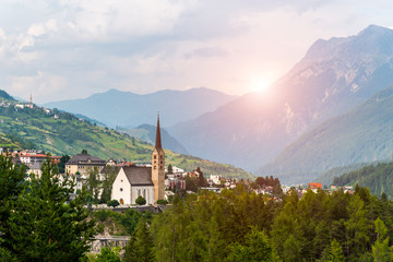 Sunset above small church in mountains Alps