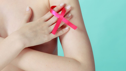 Obraz na płótnie Canvas Naked woman with breast cancer awareness ribbon