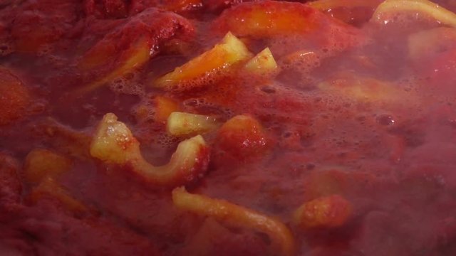 Slow motion video of stiring boiling tomato and pepper - home made tomato paste, ketchup.  Full Hd stock footage clip.
