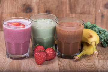 Three smoothie shakes with bananas and strawberries