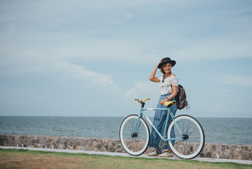 Fototapeta na wymiar Beautiful Asian girl with vintage bicycle vintage color tone