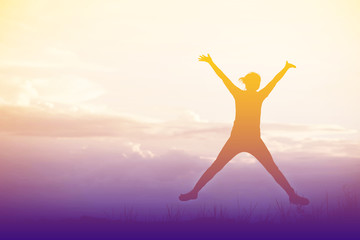 Silhouette of Happy woman jumping in green field against blue sk