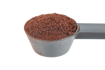 coffee powder on black plastic spoon isolated on white