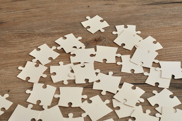 White puzzle pieces on a wooden background