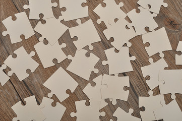 White puzzle pieces on a wooden background