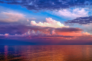 Colorful clouds over the lake in the light of sunset 