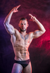 Obraz premium Handsome shirtless muscular man, standing, in studio shot