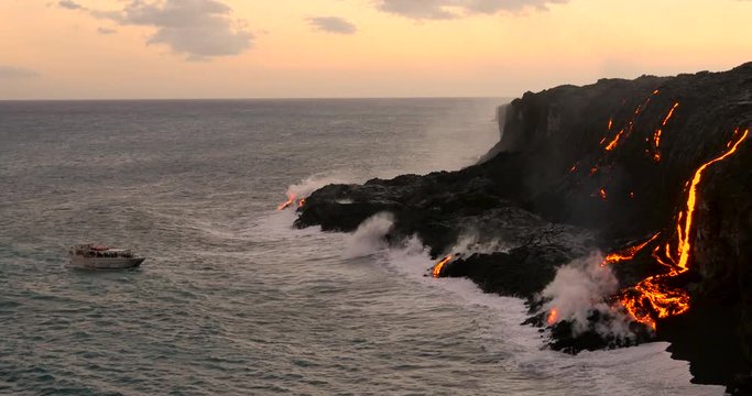 Tourist looking at Volcanic Eruption Lava flowing into the ocean. Steam rising from waves as molten lava flows into ocean waters Big Island Hawaii