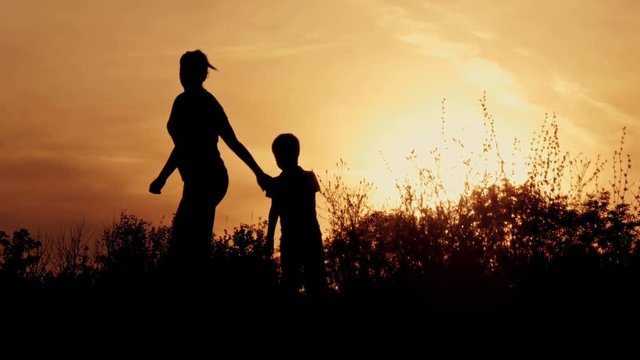 Silhouette, happy children with mother and father, family at sunset, summertime