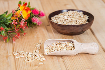 wood spoon with oats flakes pile on wood
