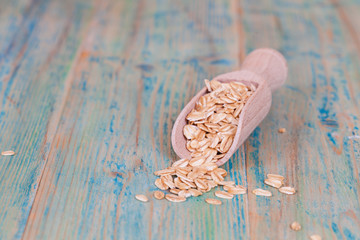 wood spoon with oats flakes pile on wood