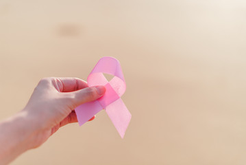 Healthcare and medicine concept - womans hands holding pink brea