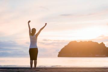 Relaxed woman breathing fresh air at on the beach sunrise.