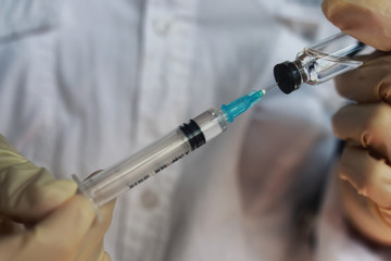 nurse hands holding syringe and ampoule
